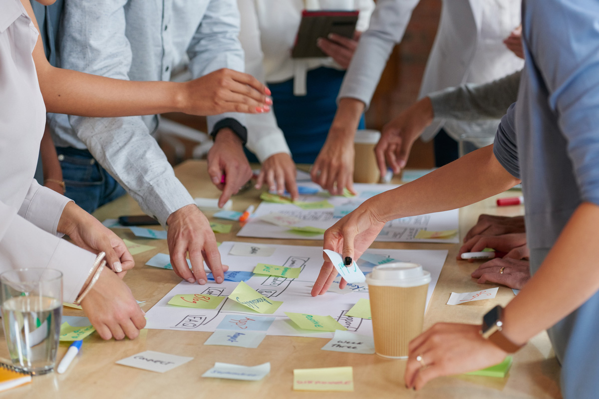 Marke & Kommunikation – Team am Tisch mit Notizen