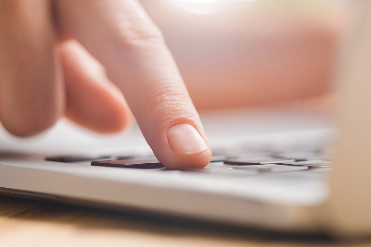 Marke & Kommunikation – trifft KI. Finger auf Tastatur in Nahaufnahme.